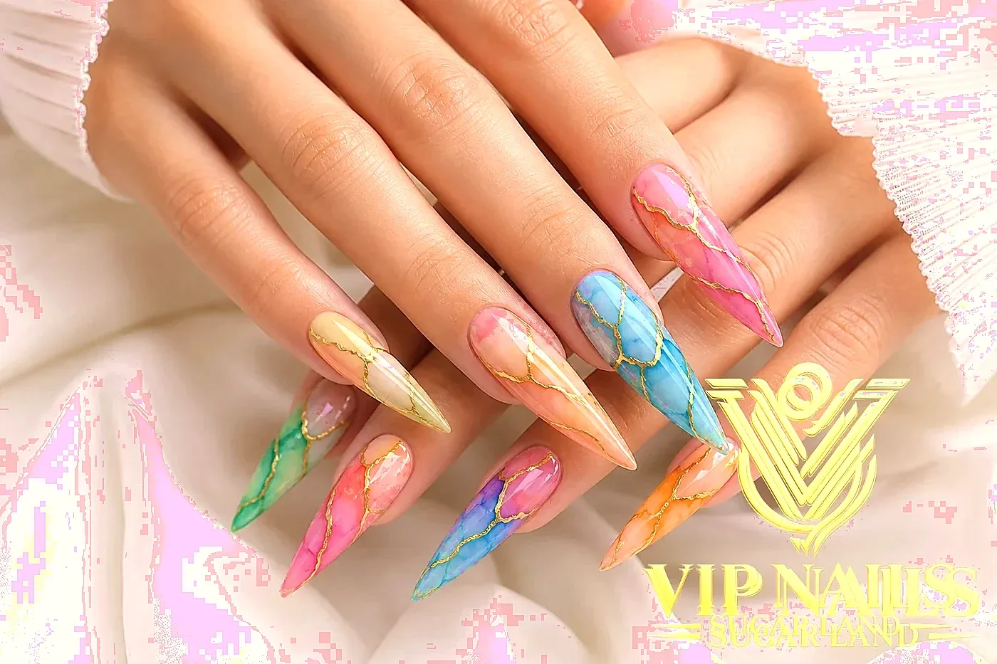 XL stiletto nails packed with 3D charms, pearls, and custom pastel art