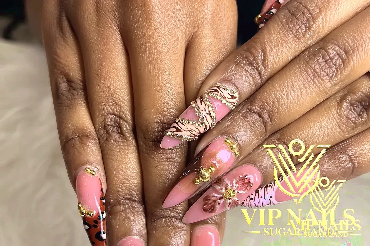 XL stiletto nails with 3D florals, rhinestone spirals, and animal print