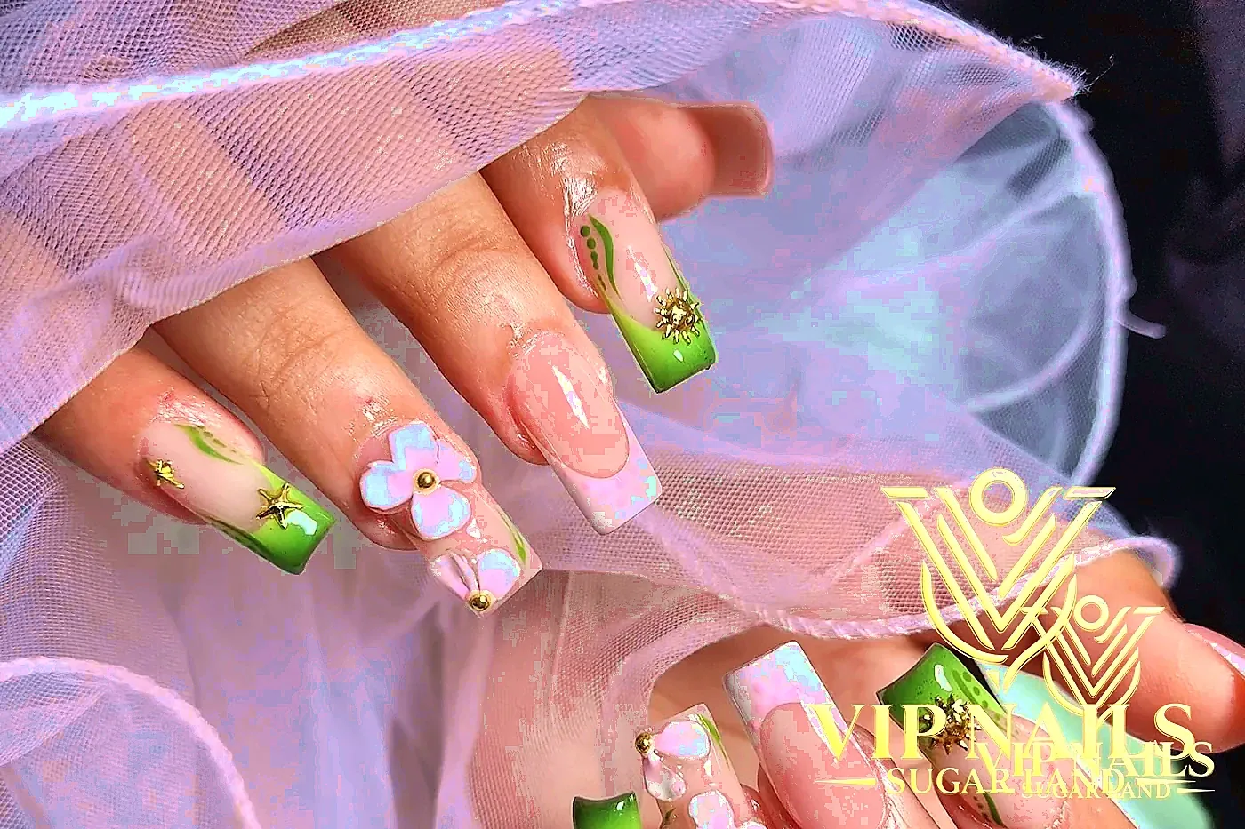 XL nails with 3D white florals, gold charms, and green vine tips