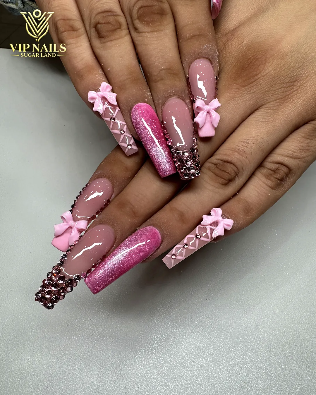 Long pink coffin acrylic set with 3D bows and gems by VIP Nails Sugar Land