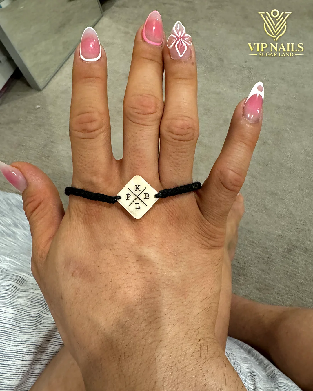 Short natural nails with pink micro-French tips and a hand-drawn accent by VIP Nails Sugar Land